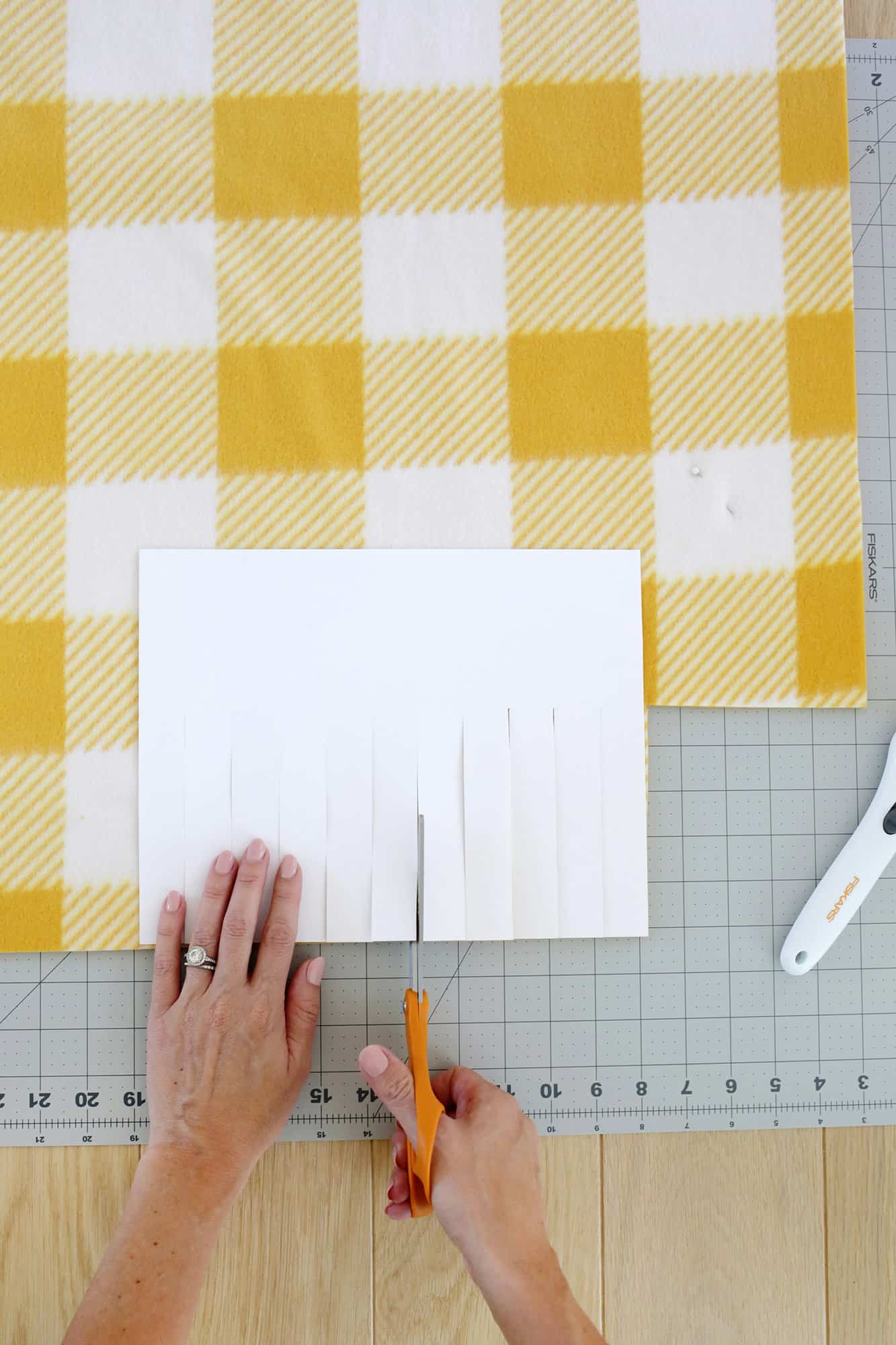 strips being cut into a fleece no sew blanket 